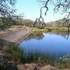 The view of Lake Ilsanjo dam from the Lake Trail. The name "Ilsanjo" is an eponymous contraction of former landowners, "Ilsa and Joe" Coney.