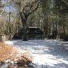 A carriage house stands shaded in the woodlands of Maudslay State Park.