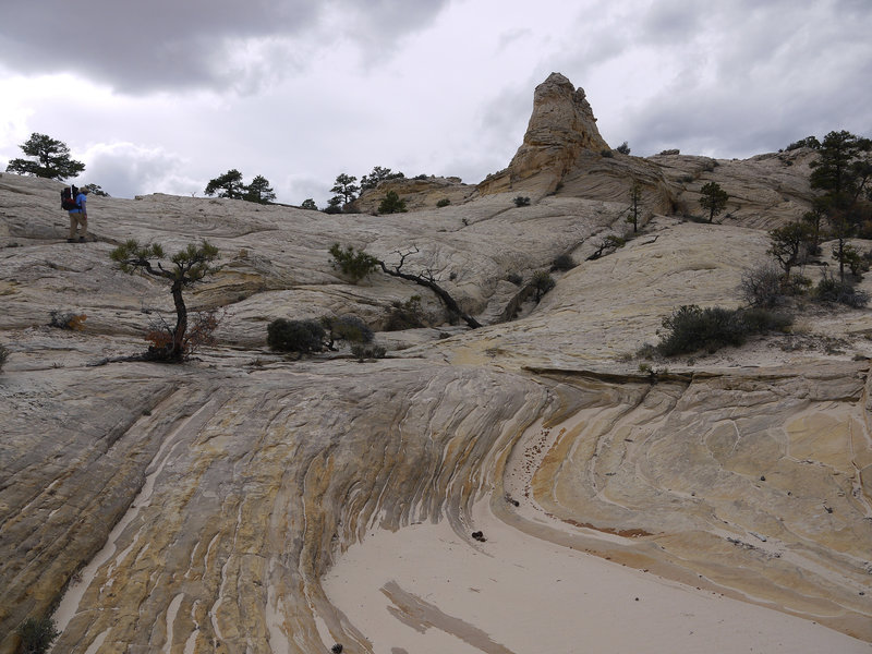 A hiker ascends a slickrock ridge on the Boulder Mail Trail.