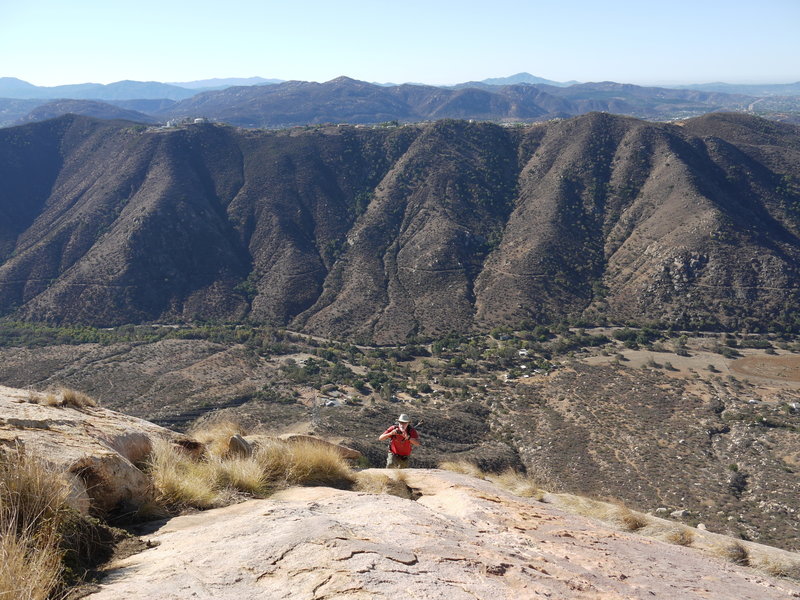 A hiker ascends the steep prow of El Cajon Mountain.