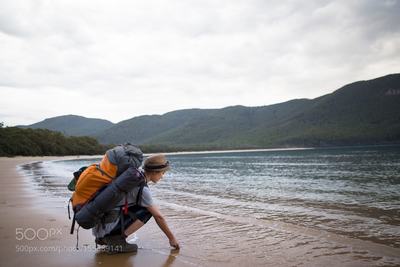 A hiker enjoys the waters of Sealers Cove.