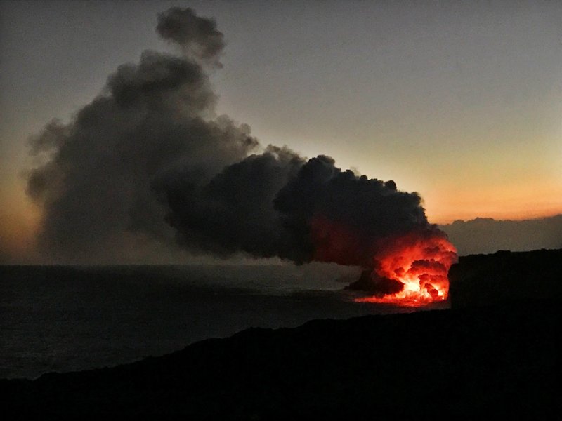 An epic sunset bolsters the view of lava flowing into the ocean from the edge of the flow in April 2017.