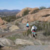 A trail runner and hiker make their way down the Mt. Gower Trail.