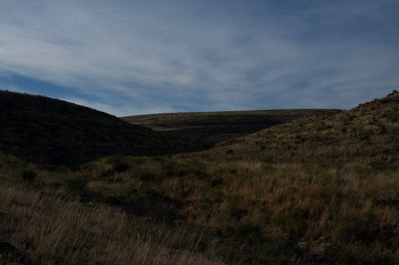 The trail ascends along the canyon to the top of a ridge.