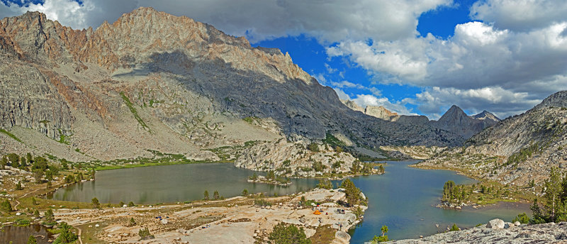 Evolution Lake glimmers in the sun with the main campsite in the foreground. Mt. Mendel and Mt. Darwin command the skyline on the right side.