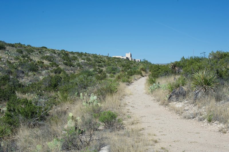 A view looking back to the visitor center; at this point, the trail goes from being paved to being gravel as it is part of the Old Guano Road.