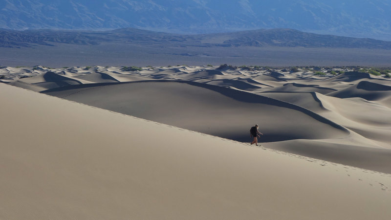 An early morning hiker sinks her soles into the Mesquite Sand Dunes.