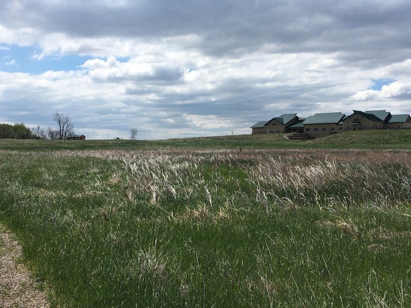 A wetland provides pleasant surroundings along the Prairie Nature Trail. The Audubon National Wildlife Refuge Visitor Center is in the background.