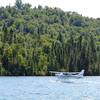 A seaplane daintily lands on the water near Windigo.