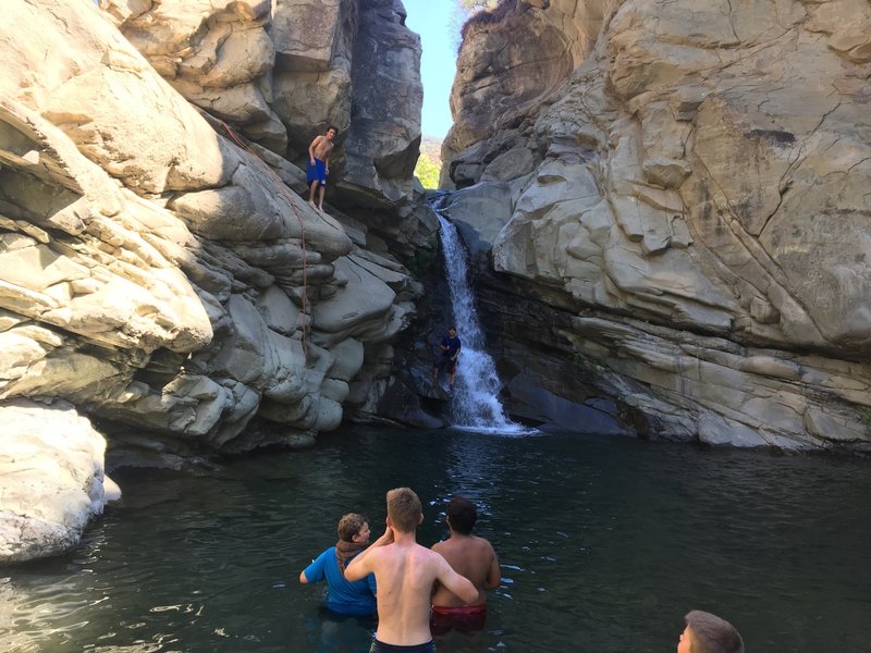 A teenager gets ready to jump off the cliff.