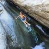 A kid slides on the rocks next to Cross Camp.