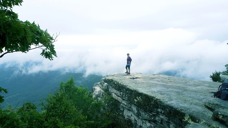 A hiker enjoys her reward on McAfee Knob.