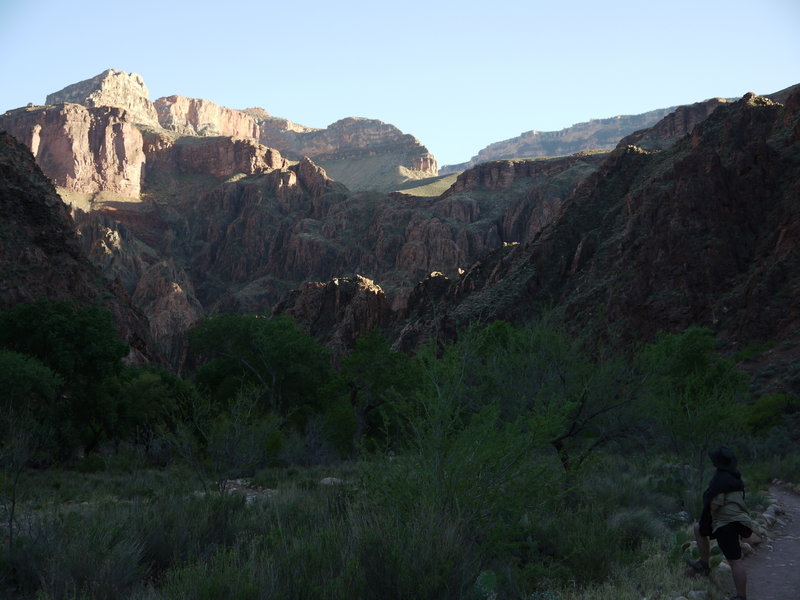 A hiker watches the late-afternoon sun on the canyon wall from near Bright Angel Campground.