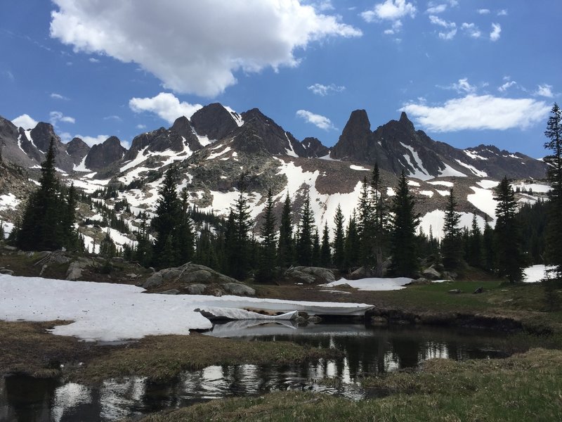 Enjoy great views of snowy mountains in July from the high meadow before the ascent up the ridge.