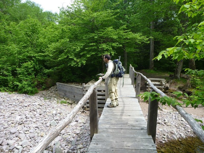 A hiker crosses the East Branch Neversink River.