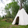 A seasonal teepee can be found in a grove of trees near the creek.