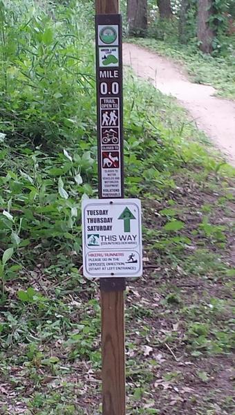 Directional sign at trailhead; trail direction alternates daily.