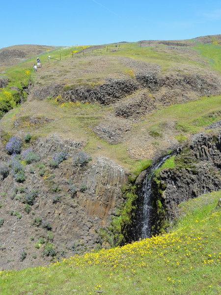 Percolated water creates a small waterfall in front of an old ranching fence at the top of the ridge.