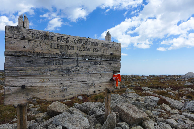 A weathered sign greets you at the pass