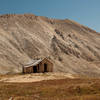 An old mining cabin with an impressive backdrop.