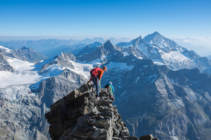 Climbers descending the Hornli Ridge on the Matternorn. In the background is the Ober Gabelhorn, the Zinalrothorn, and the Weisshorn.