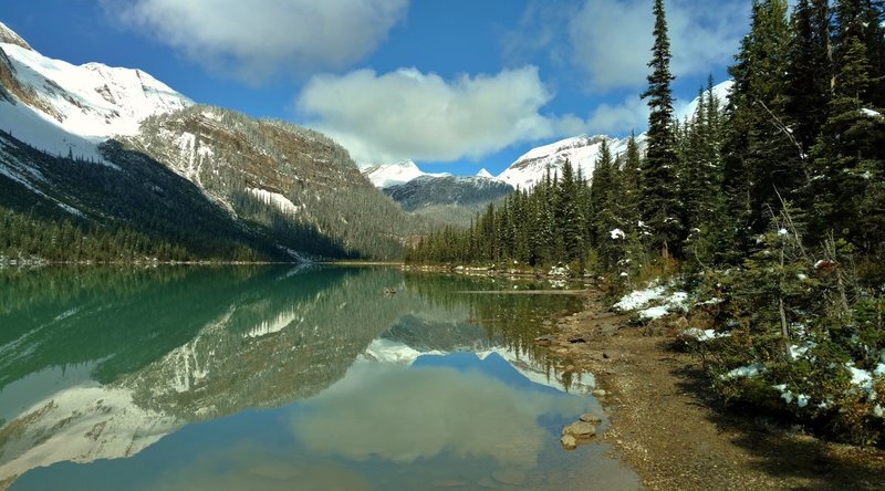 Mountains surrounding Sherbrooke Lake are mirrored in Sherbrooke Lake, looking north on a bright September morning