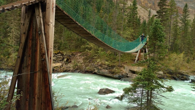 Crossing the swift flowing Robson River on a suspension bridge near the Whitehorn trail camp