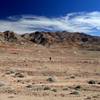 Crossing the gravelly plain, the mouth of Monarch Canyon above the person