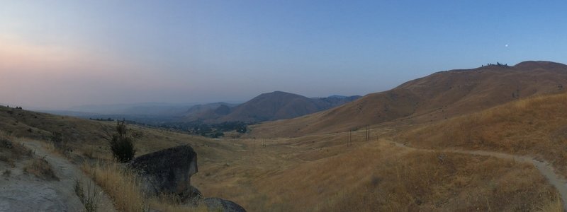 Smokey sunrise opposite the moon with Wenatchee Valley in between.