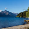 Small boats are anchored at the shore of Lake Wakatipu