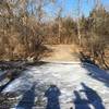 A frozen, paved creek crossing.