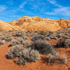 Open desert surrounded by red and beige sandstone hills.