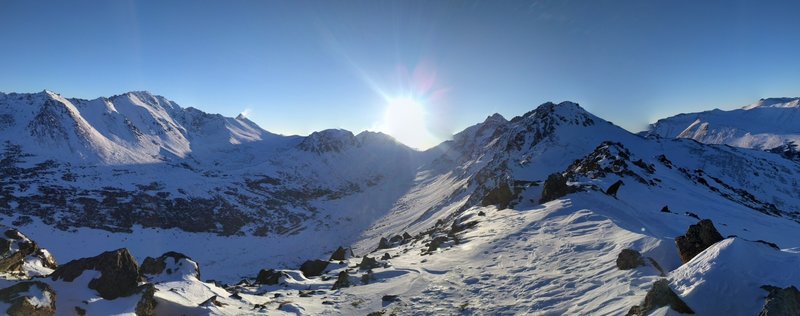 View from Peak 2 looking southeast. Powerline Pass is just below the sun and Ptarmigan Peak is the first peak to the right of the sun.