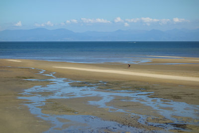Couple exploring shallow Porters Beach beyond the Abel Tasman Coast Track