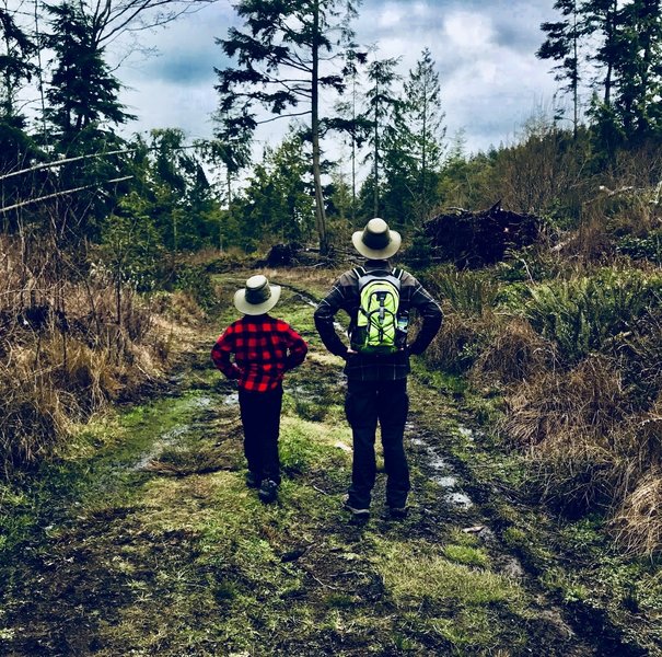 Two hikers pose in a clearing.