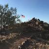 The trail continues past the flag to make its way to the summit.