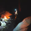 Travel companion drinking some late night tea next to a fire, in one of the backcountry camping sites at Cloudland State Park.