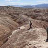 Two hikers descend into the badlands near Font's Point.