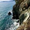 Waves crashing against the cliff side.