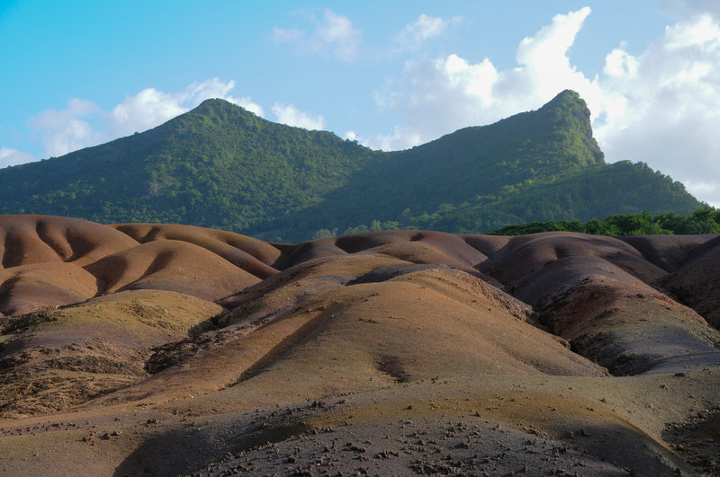 A small mountain offers a lovely backdrop to the seven coloured earths