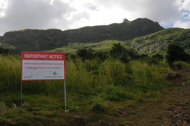 An ominous sign at the trial head, but the trail seemed safe enough. The "thumb" shaped point right of center is the summit. Prominent rock-cut switchbacks can be seen to the far left.