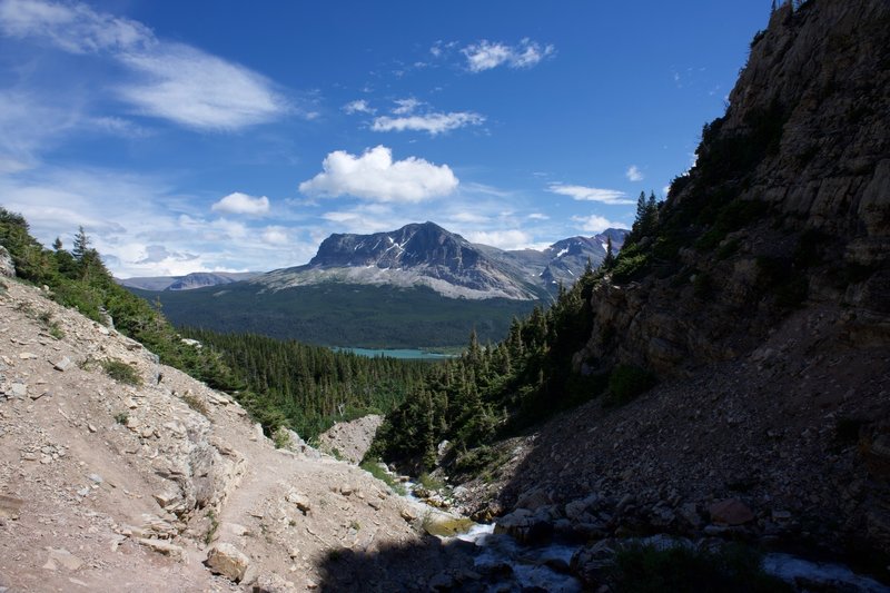 Lake Sherburne and Wynn Mountain can be seen across the valley from the waterfall.
