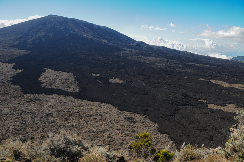 Newer lava flows are clearly visible as darker black rock.