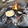 Cooking up dinner over the campfire.