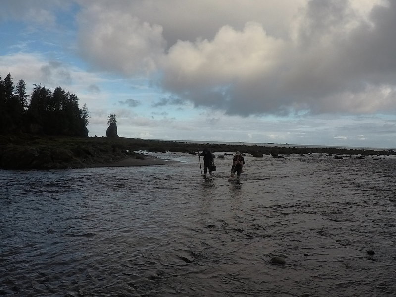 Two hikers fording the Ozette River.