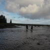 Two hikers fording the Ozette River.