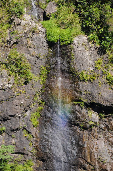A small waterfall plunges towards Bras Bemale while creating a small rainbow