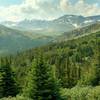 Forested hills, ridges, and snowy moubtains to the east, as seen from Pobotkan Pass Trail, as the trail begins its descent to the John-John Trail Camp.