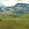 Mountains, snowfields, glaciers, and a small lake rise above the Jonas Creek valley at the creek's headwaters. Seen just below Jonas Shoulder when looking west.