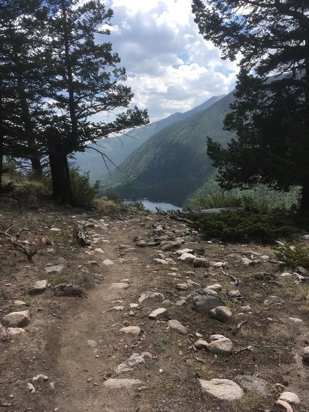 This is about mile 4 on Segment 13 just before you descend the switchbacks to Avalanche Trailhead. The lake is called Rainbow Lake.  You'll see it again when you start climbing the other side.